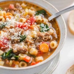 Italian sausage soup in a bowl garnished with Parmesan.