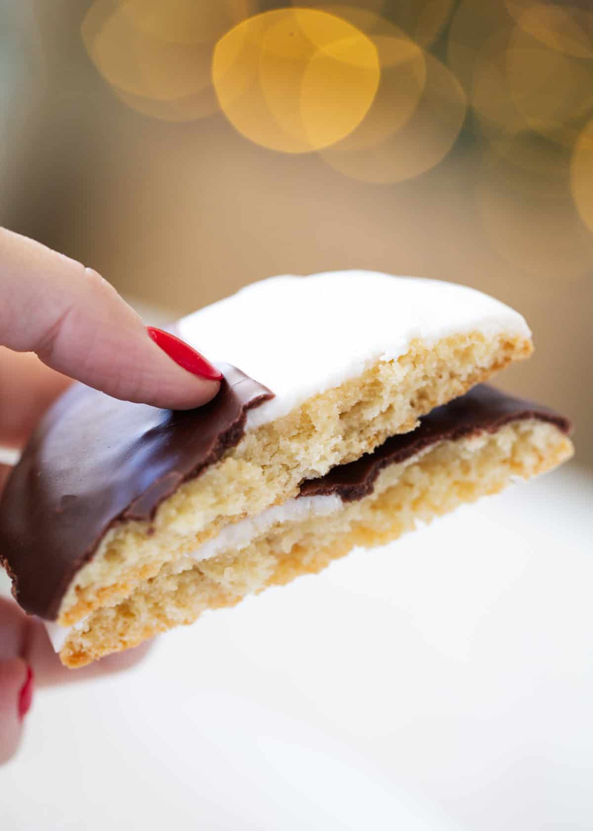 These black and white cookies are made with a thick, cake like cookie topped with both vanilla and chocolate frostings. A staple in New York City bakeries now made at home! Black and white cookies cut in half.
