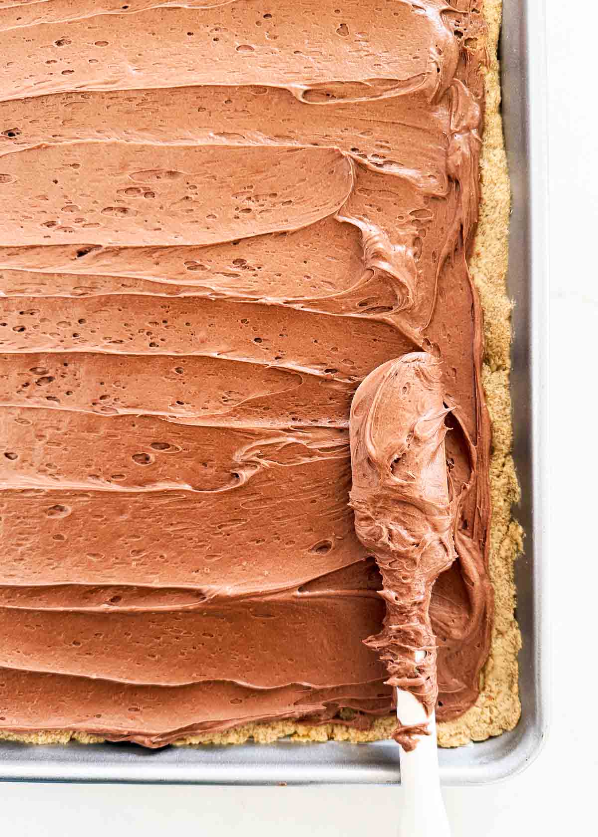 Spreading frosting on peanut butter bars.