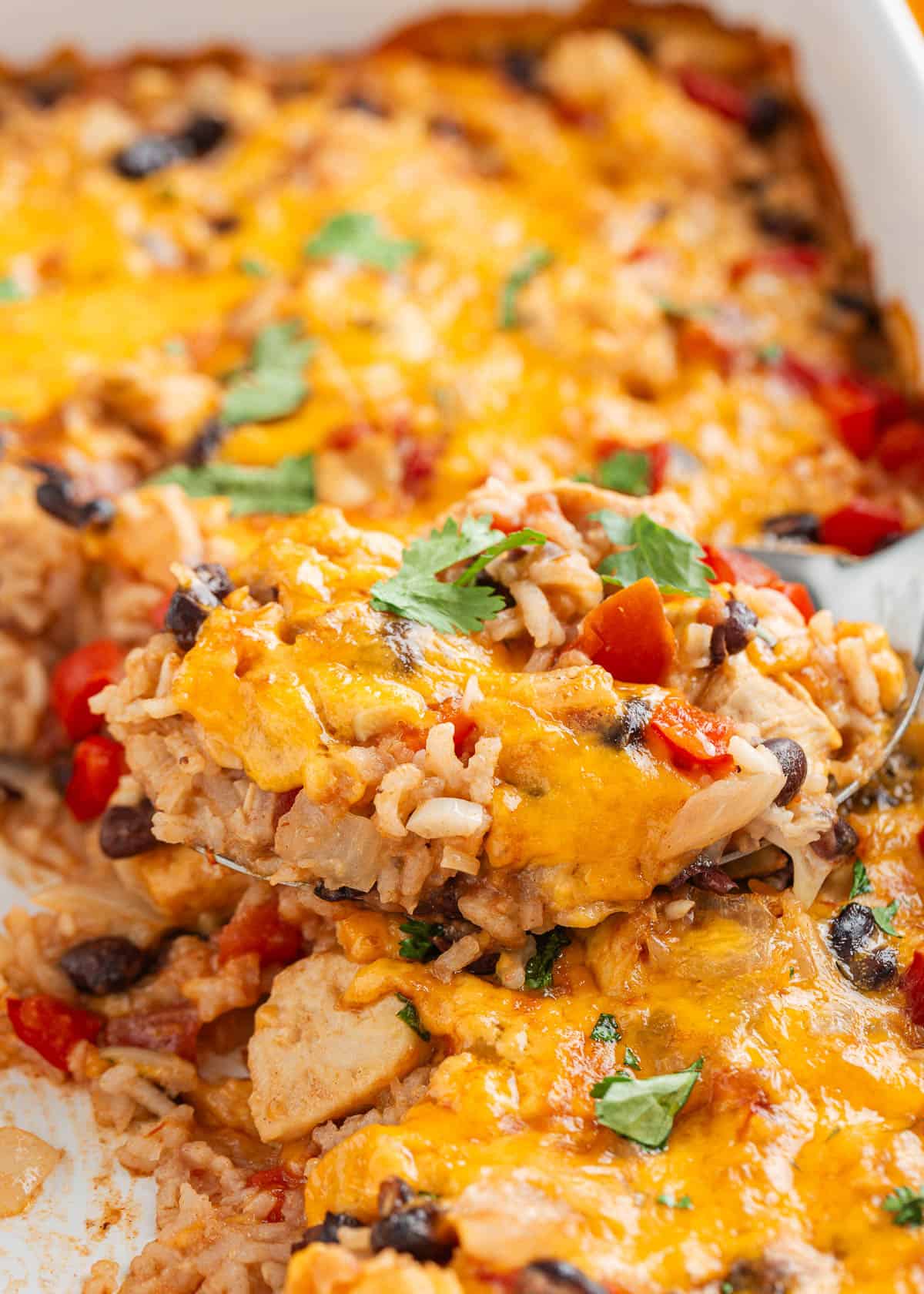 Prep this one-pan meal in 10 minutes and enjoy this cheesy Mexican chicken and rice bake in 1 hour with all your favorite toppings. No side dishes are needed tonight! Mexican chicken and rice bake in a casserole dish.