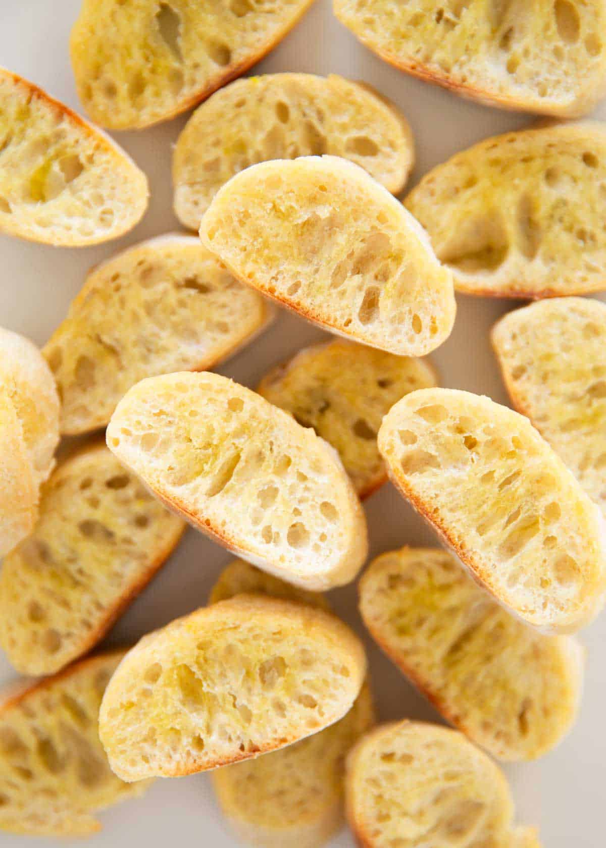 Learn how to make crostini that is crisp, buttery and delicious! Making these homemade toasted slices of baguette is so easy, yet looks so impressive with a variety of toppings. Showing how to make crostini.