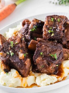 Red wine braised short ribs over mashed potatoes with rich sauce and fresh thyme.