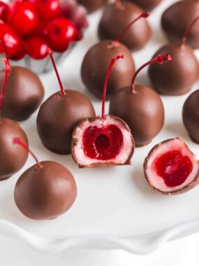 Chocolate covered cherry on a white plate.