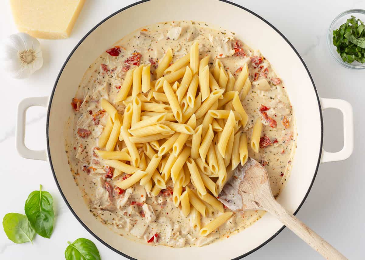 Marry me chicken pasta cooking in a skillet.