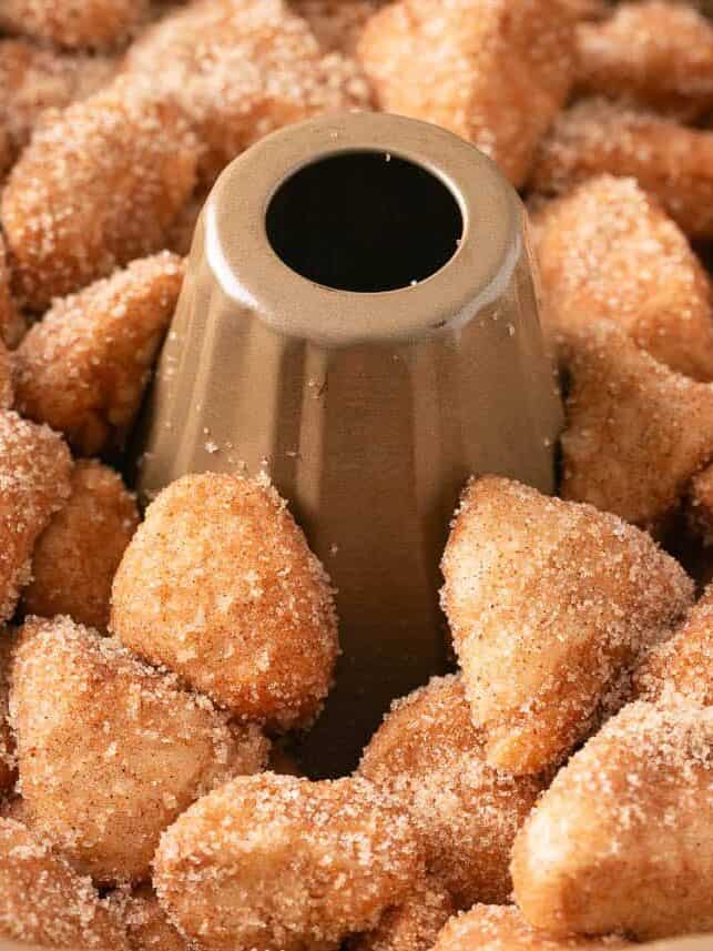 Biscuit pieces coated in cinnamon sugar in a bundt pan.