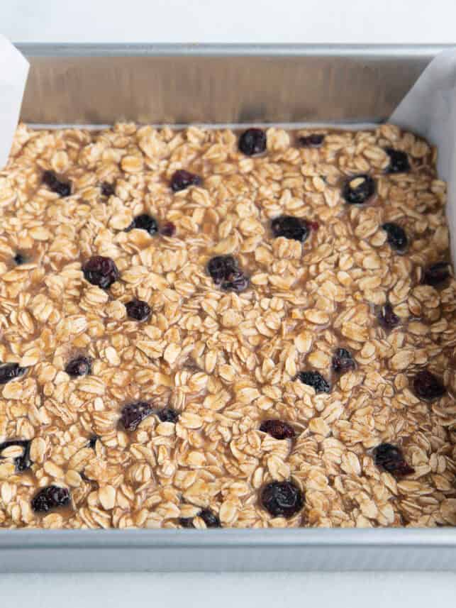 These oatmeal breakfast bars are soft, chewy and a healthy start to the day! They are quick and easy to meal prep in advance for breakfast and snacks. Unbaked oatmeal breakfast bars in a pan.