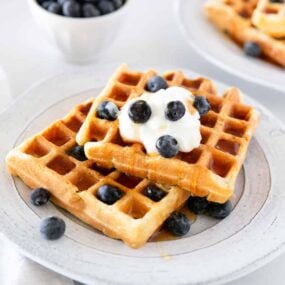 Sourdough waffles on a plate with blueberries.