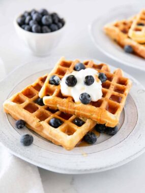 Sourdough waffles on a plate with blueberries.