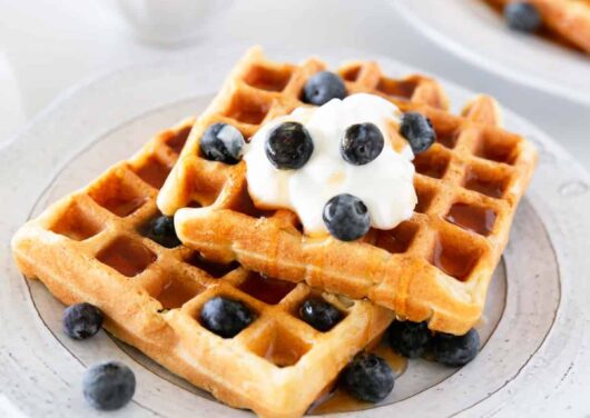Sourdough waffles on a plate with blueberries.