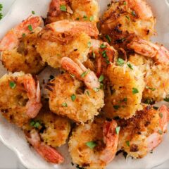 Close up of fried coconut shrimp on a plate showing crispy texture.