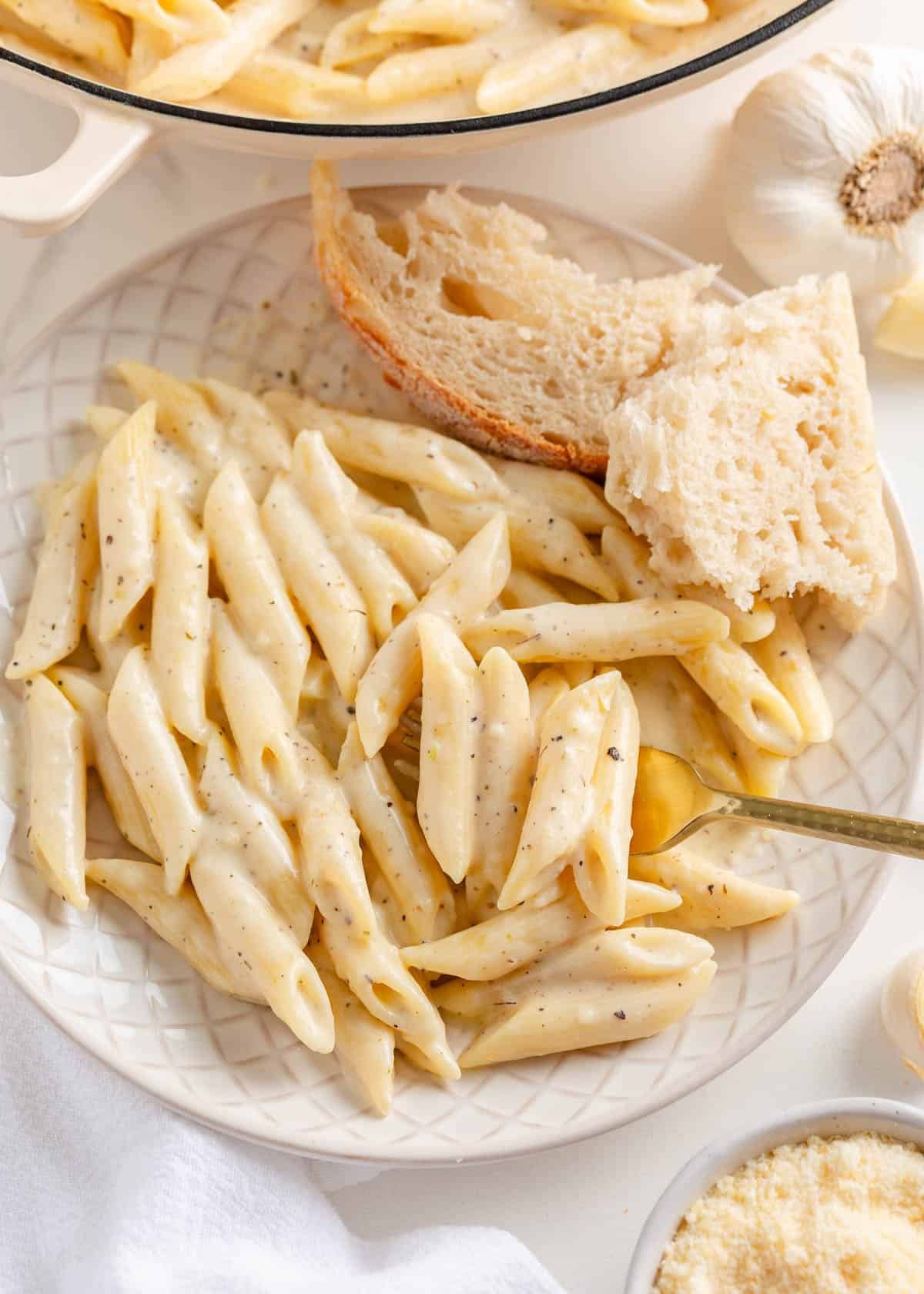 Penne pasta recipe on a plate with bread.