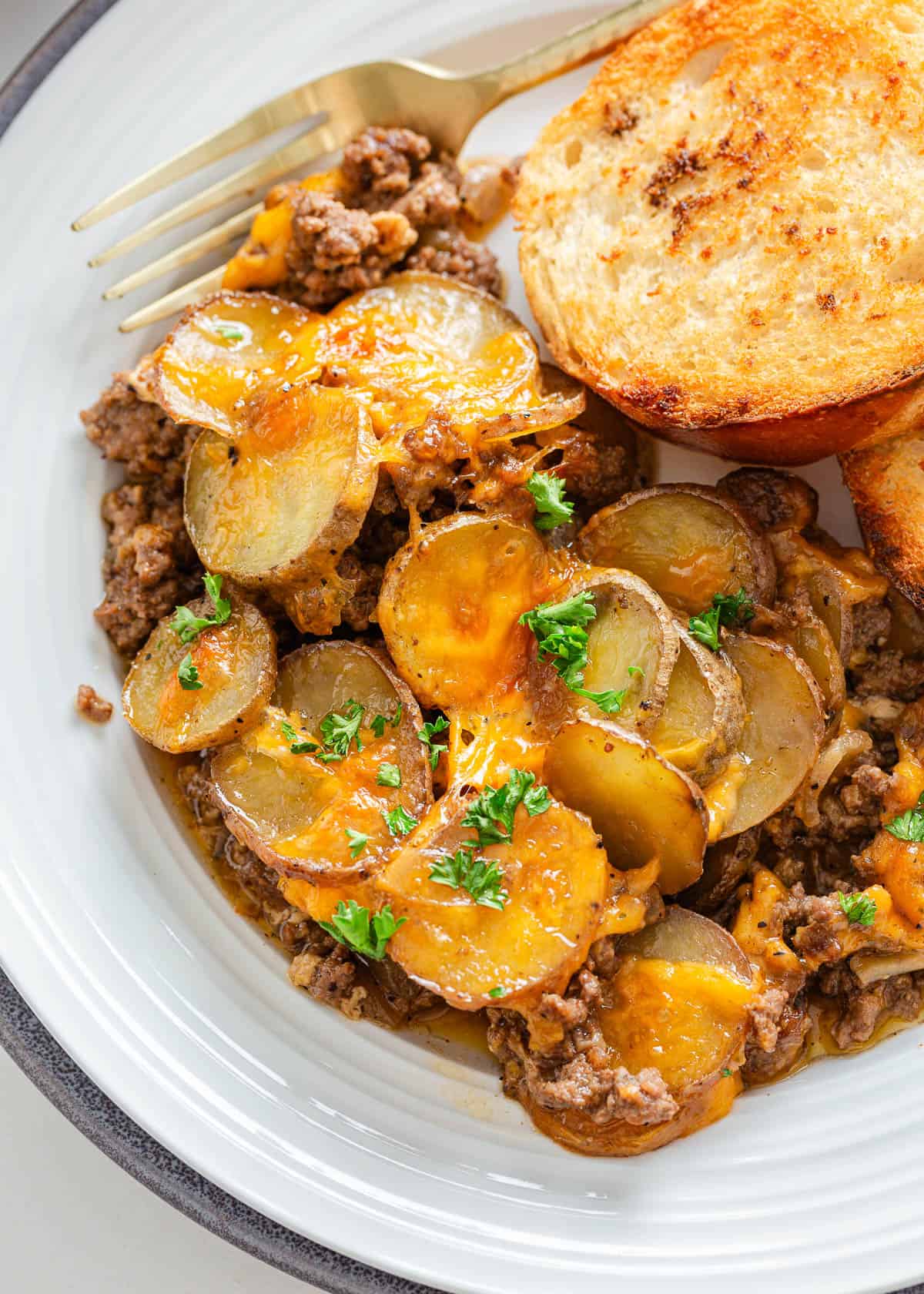 Simple yet packed with flavor, this ground beef and potatoes is an easy to make 'meat and potatoes' skillet recipe full of cheesy comfort that the whole family will love! Ground beef and potatoes on a plate.