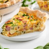 Ham and cheese quiche on a plate.