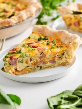 Ham and cheese quiche on a plate.