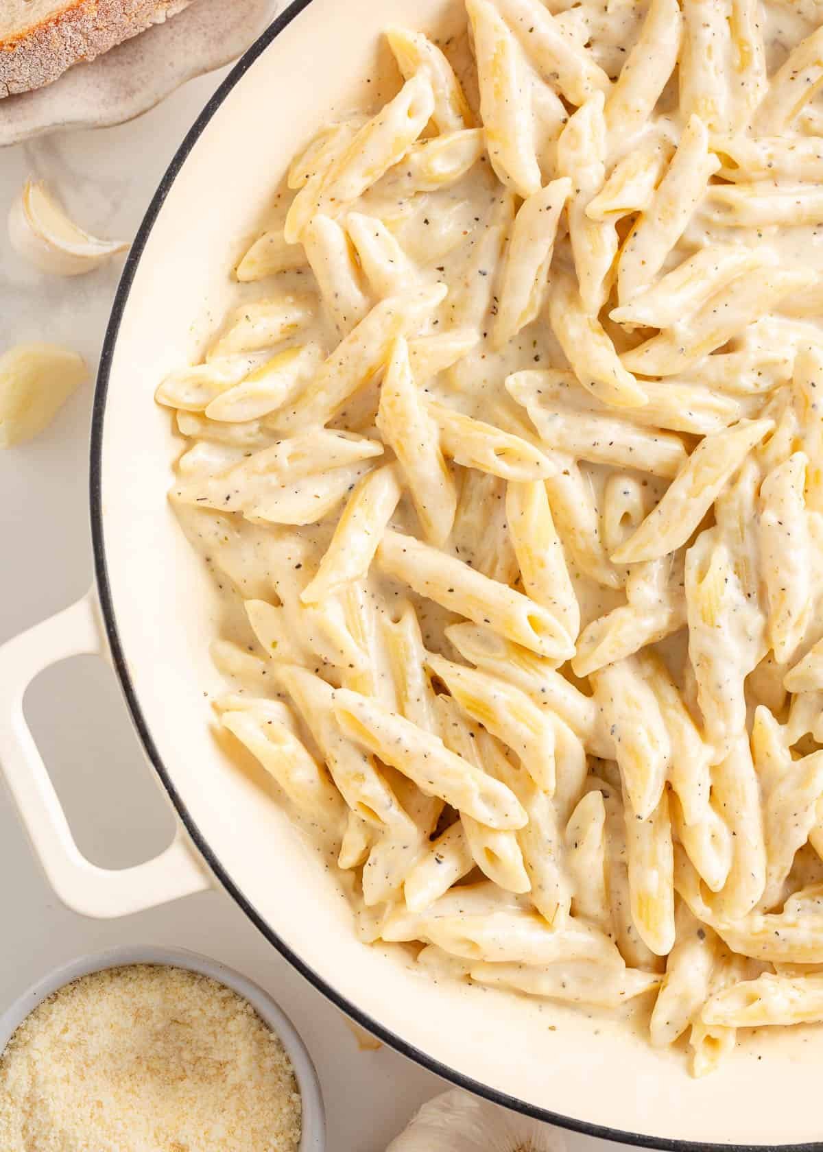 Penne pasta in a large white skillet.