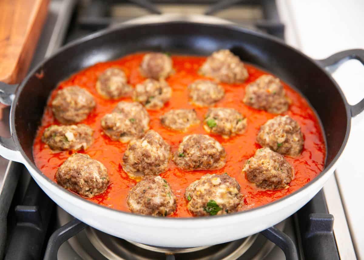 Showing how to make ricotta meatballs in a skillet.