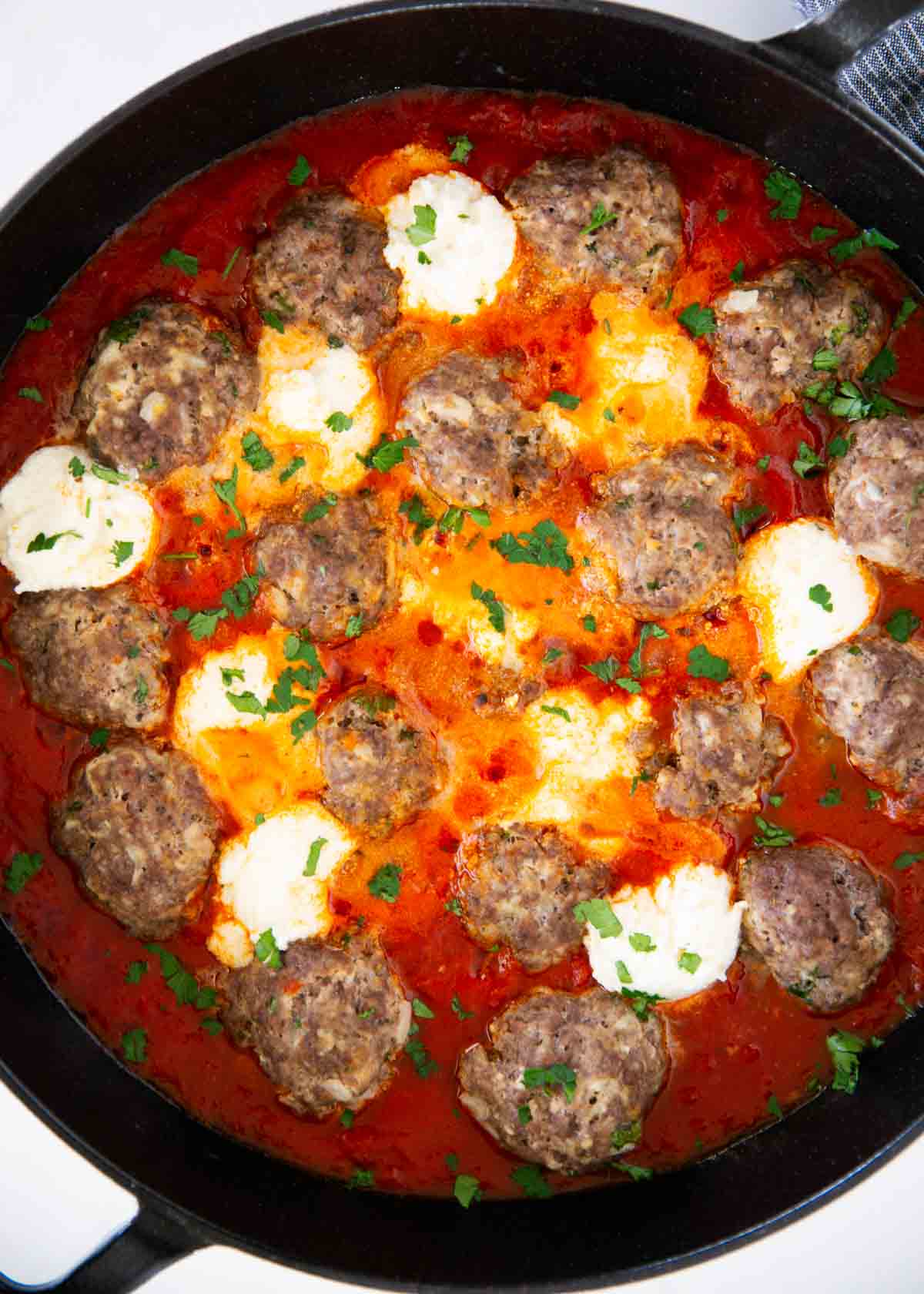 Ricotta meatballs in a cast iron skillet.