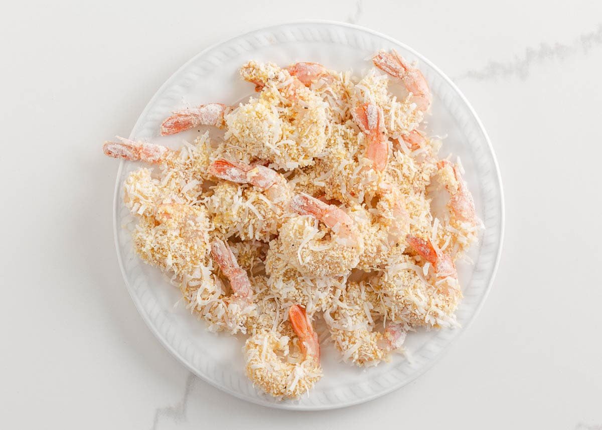 Raw coconut breaded shrimp on a plate.