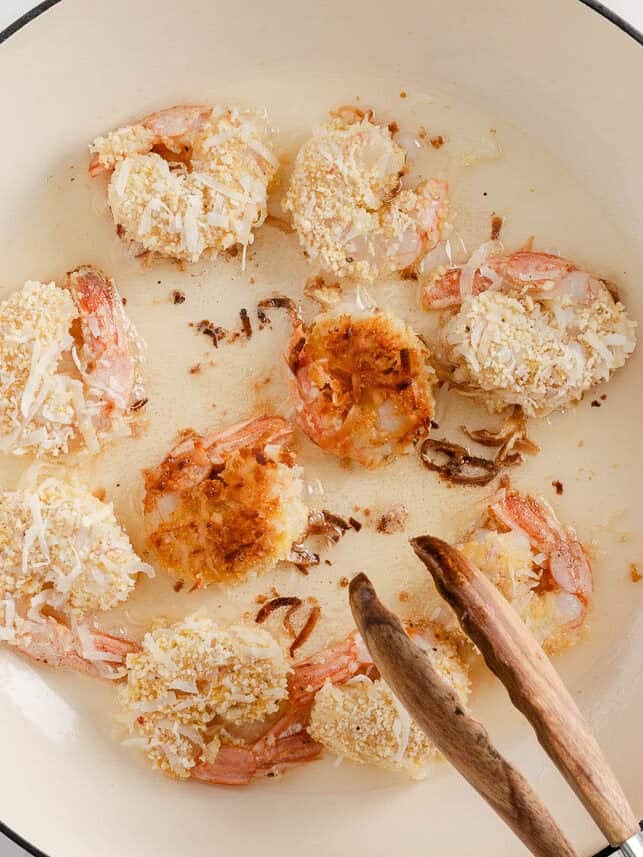 Frying coconut shrimp in a skillet.