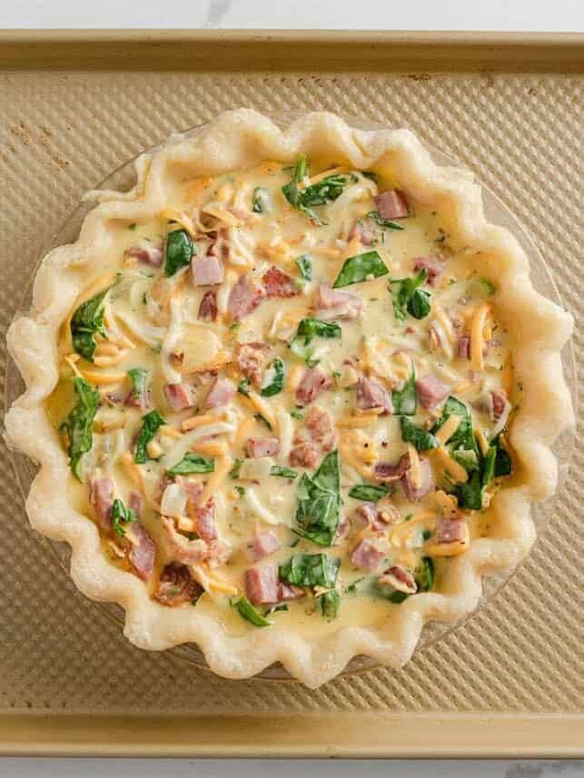 Unbaked ham and cheese quiche in a pie crust.