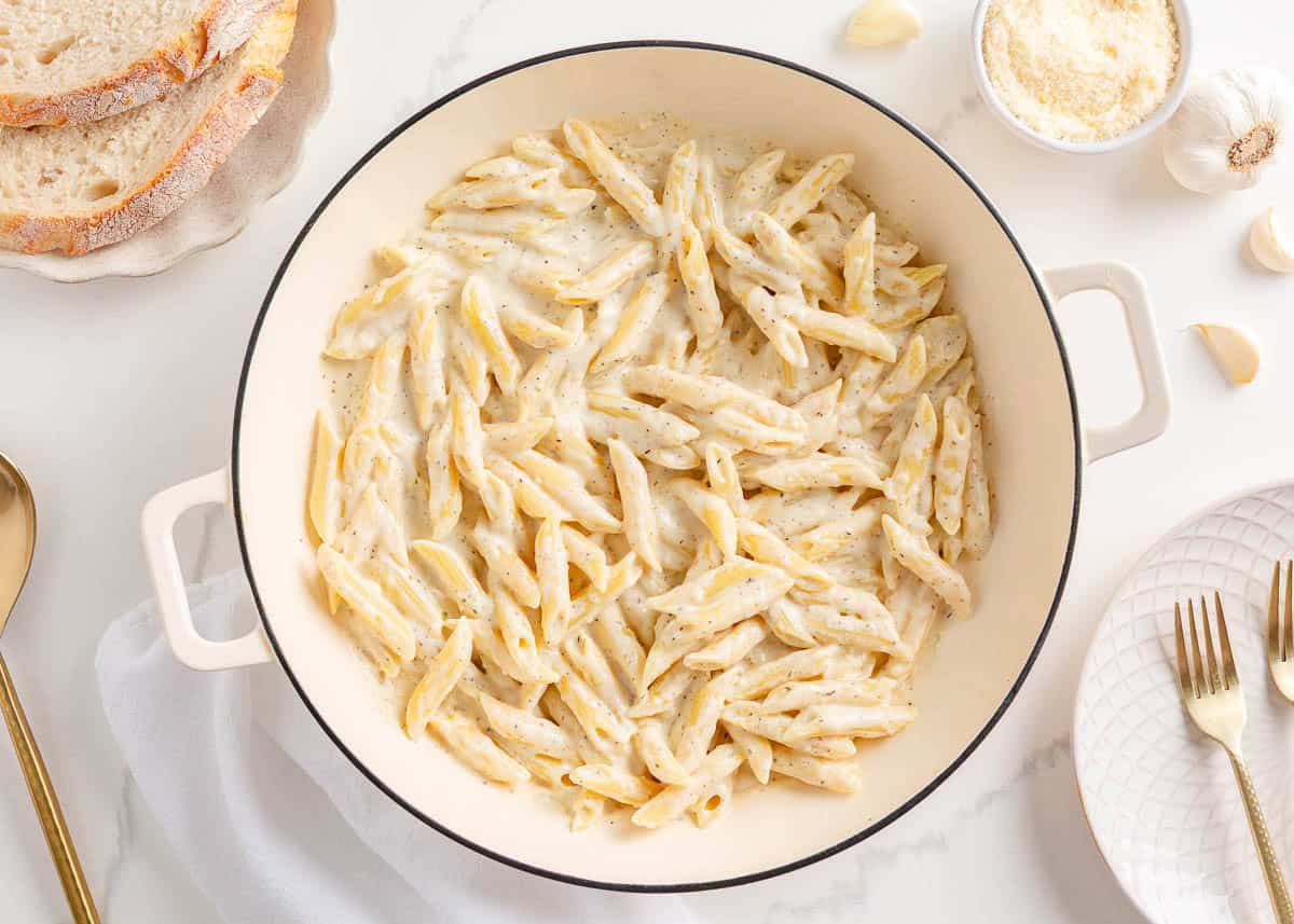 Penne stirred into pasta sauce.