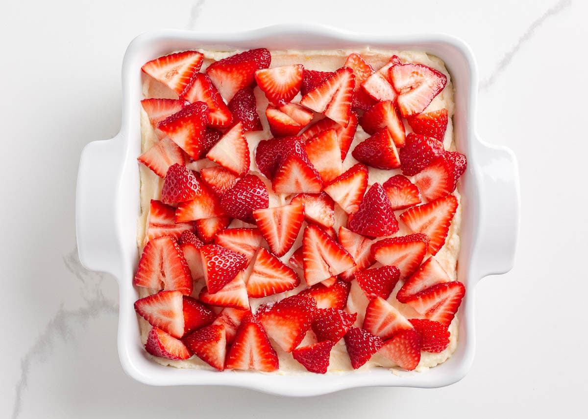 Topping strawberry tiramisu with fresh sliced strawberries.