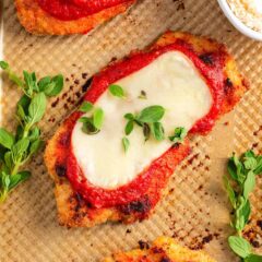 Baked chicken parmesan recipe on baking sheet.