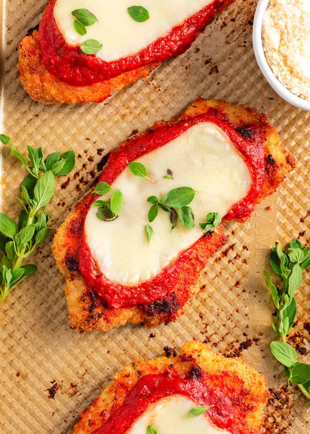 Baked chicken parmesan recipe on baking sheet.