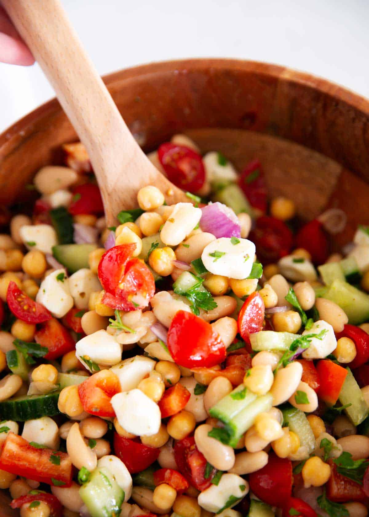 Learn to make this simple, dense bean salad TikTok sensation! It's fresh and healthy, vibrant and colorful, with plenty of crunch, then tossed in a tangy homemade dressing. Dense bean salad in a bowl.