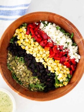 Arugula chopped salad with creamy basil dressing in a large salad bowl.