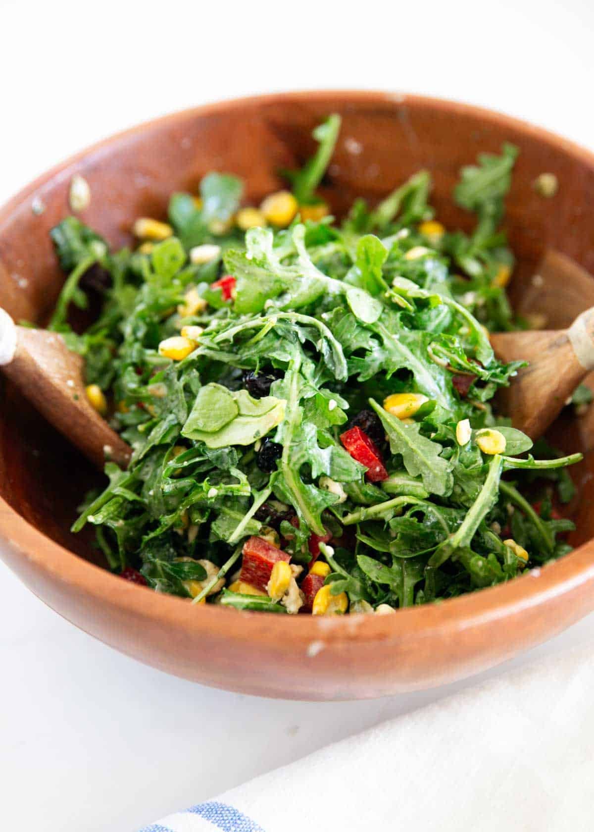 Tossing the ingredients for arugula chopped salad together in a large bowl. 