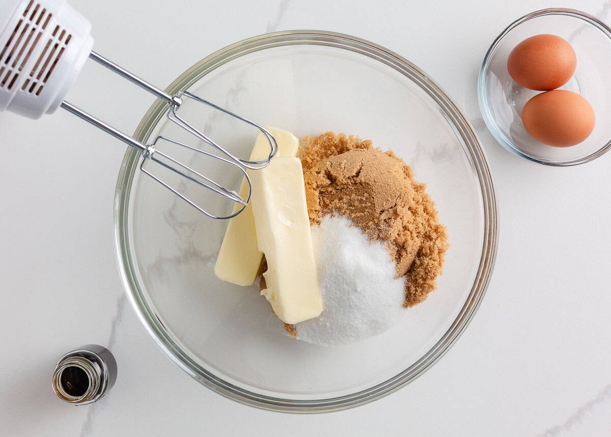 Butter, brown sugar and sugar in a mixing bowl with beaters.