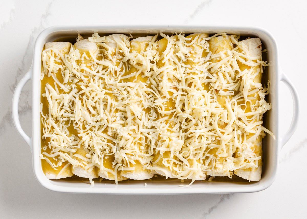 Unbaked cream cheese chicken enchiladas in a baking dish.