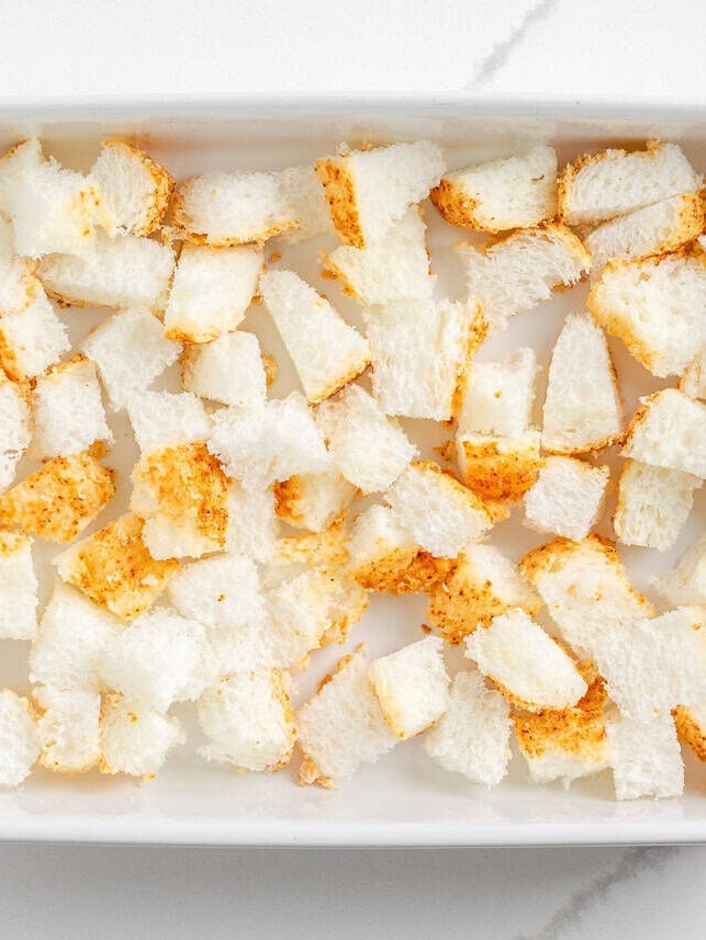 Angel food cake cubed in a baking dish.