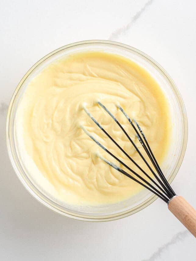 Sour cream and pudding mixture being whisked together.