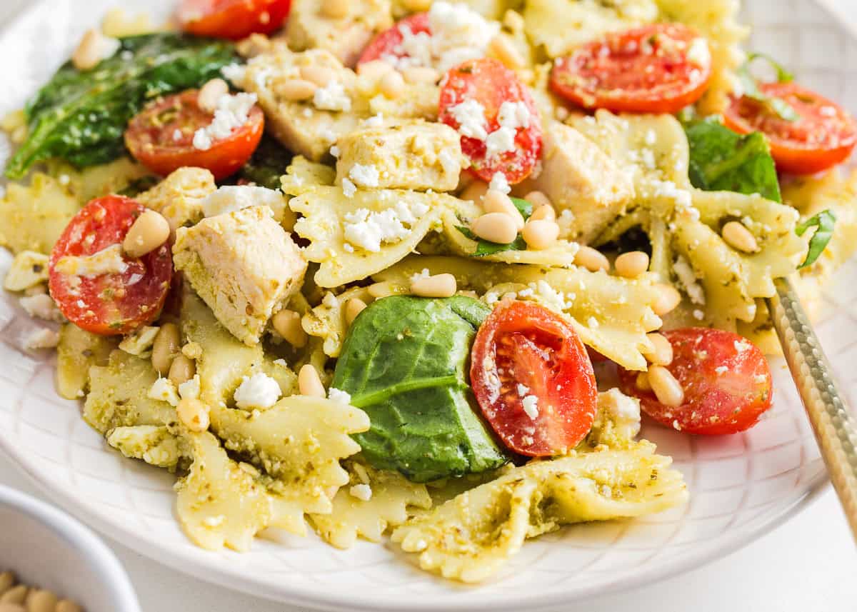Chicken pesto pasta salad on a white plate.