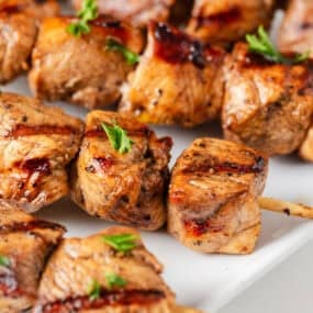 Chicken skewers on a plate.