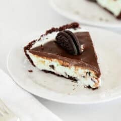 A slice of grasshopper pie with mint ice cream on a plate.