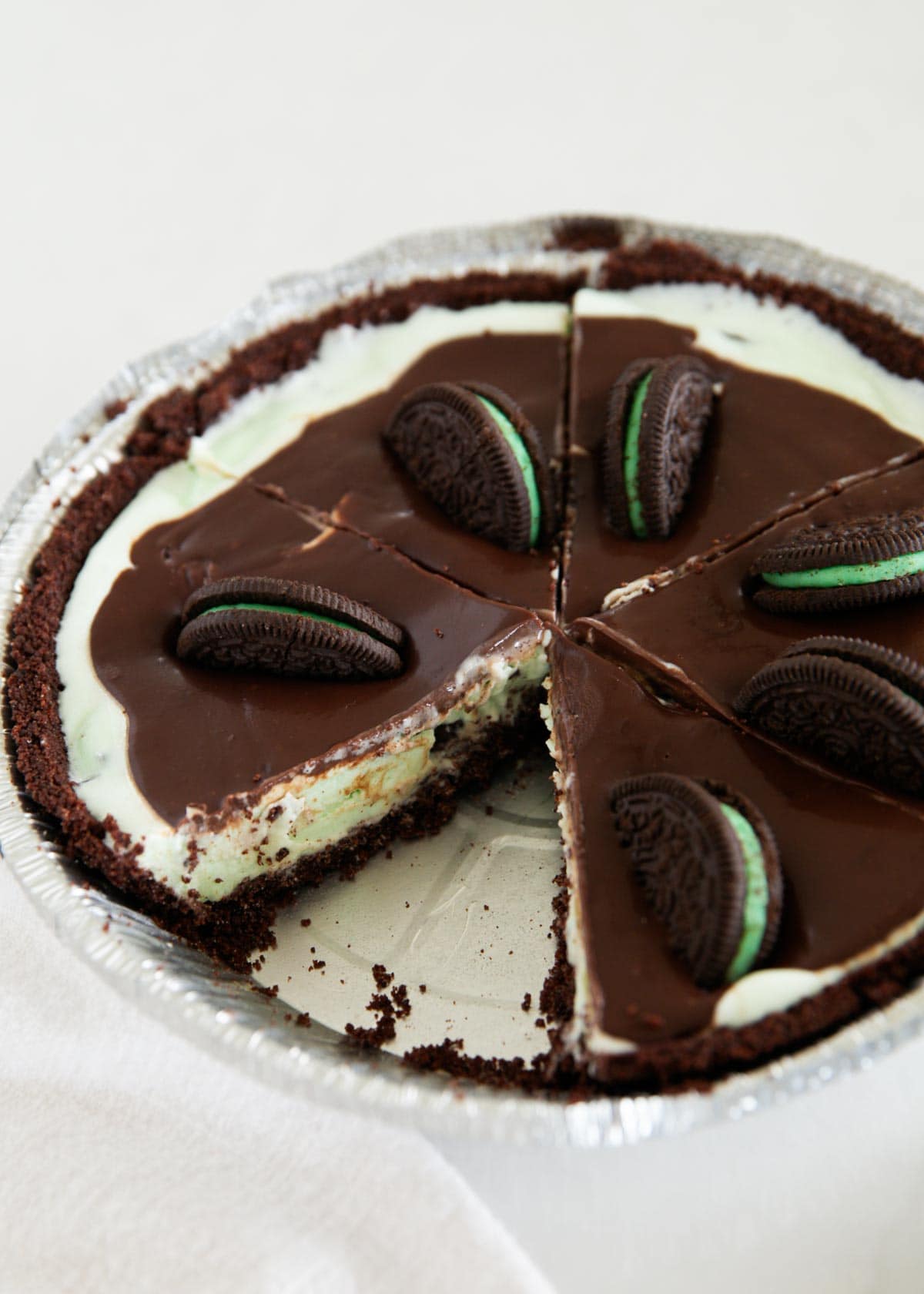 A grasshopper pie made with mint chip ice cream and chocolate ganache sliced.