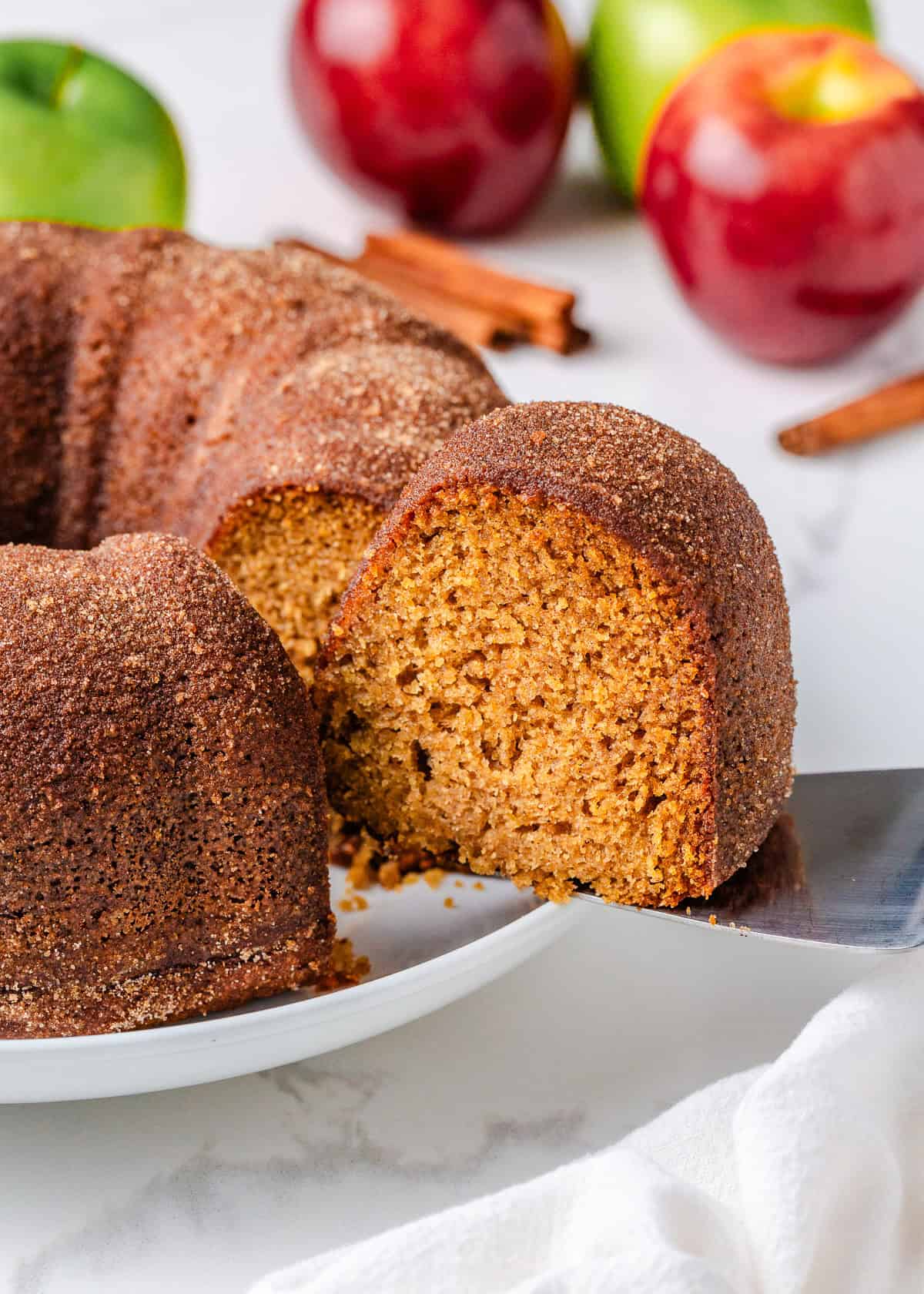 A slice of apple cider doughnut cake being served.