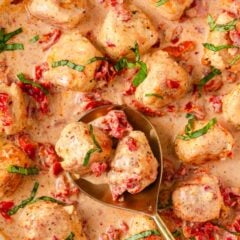 Close up picture of marry me chicken meatballs served with gold spoon.
