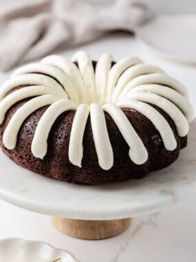 Chocolate chocolate chip nothing bundt cake on a cake stand.