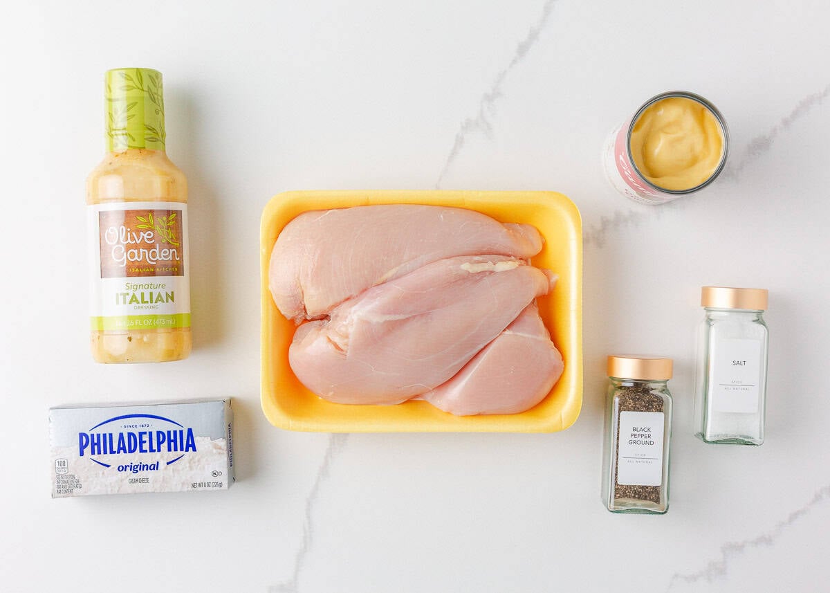 Olive Garden chicken pasta combines tender chicken slow-cooked in a rich, creamy, zesty sauce served over your favorite pasta, for the perfect weeknight meal at home! Ingredients for olive garden chicken pasta including chicken breasts, Italian dressing, cream cheese, and seasonings.