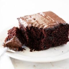 A slice of chocolate crazy cake on a plate with a fork.
