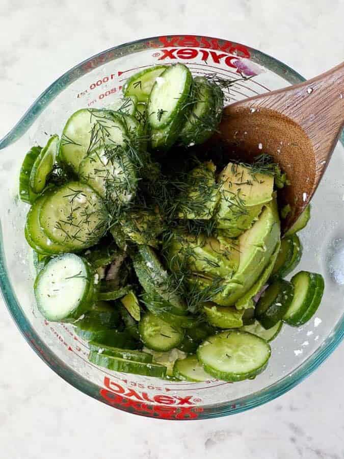 Showing how to make avocado cucumber salad.