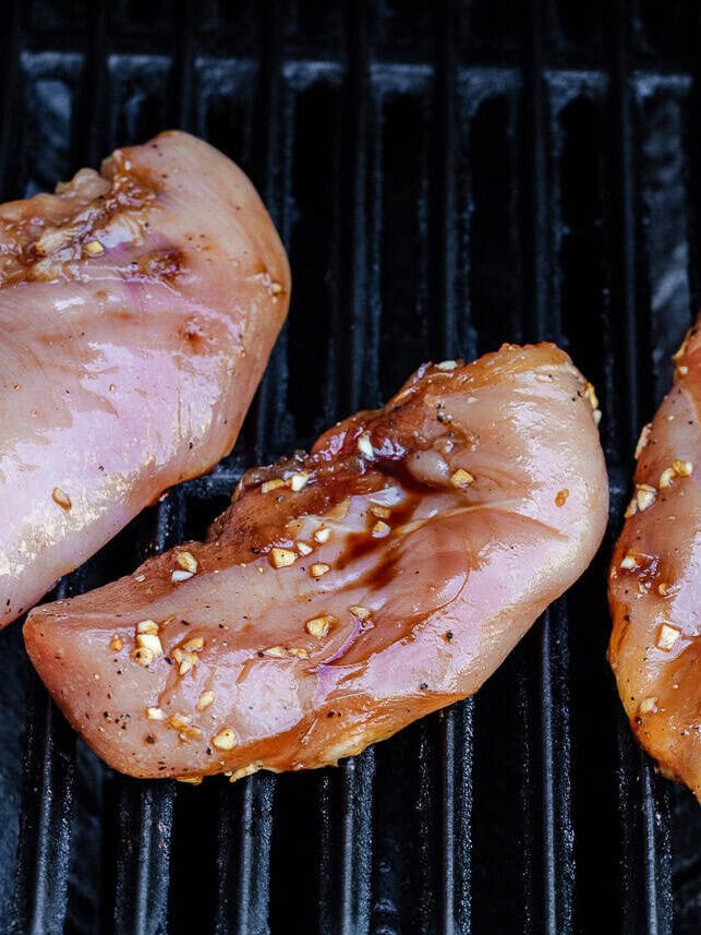 Marinated chicken breast on grill.