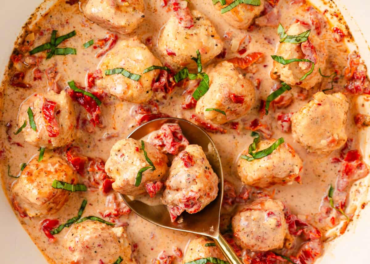 Marry me chicken meatballs in a pot with serving spoon.