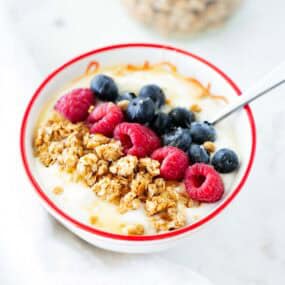 Nut free granola in a bowl with berries.