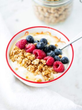 Nut free granola in a bowl with berries.