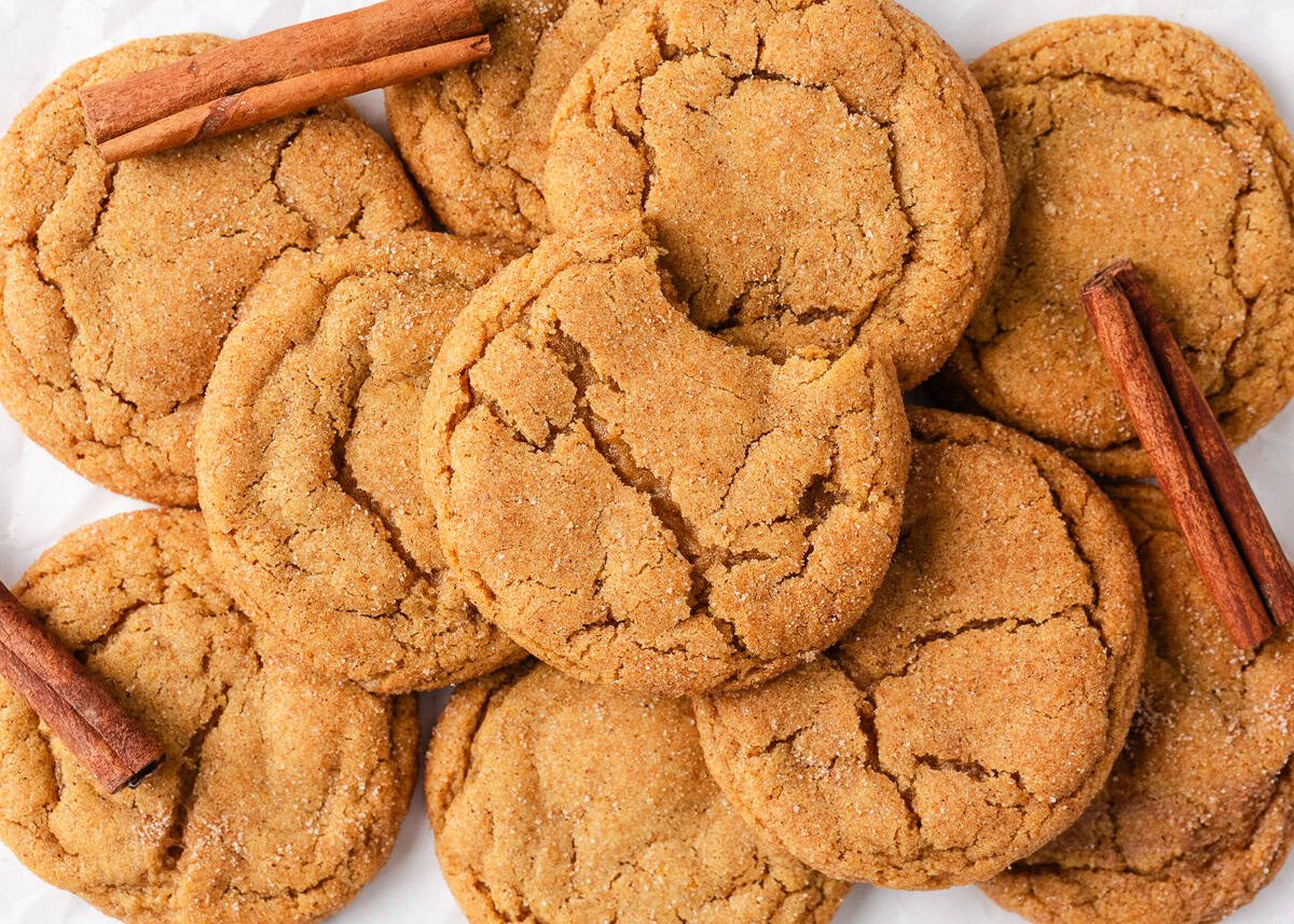 Perfectly spiced and deliciously sweet with the nutty aroma of brown butter, these chewy brown butter pumpkin cookies deliver all the fall coziness in every bite! Flat lay of golden maple chewy pumpkin cookies made with brown butter showing crinkled tops and cinnamon sugar coating.